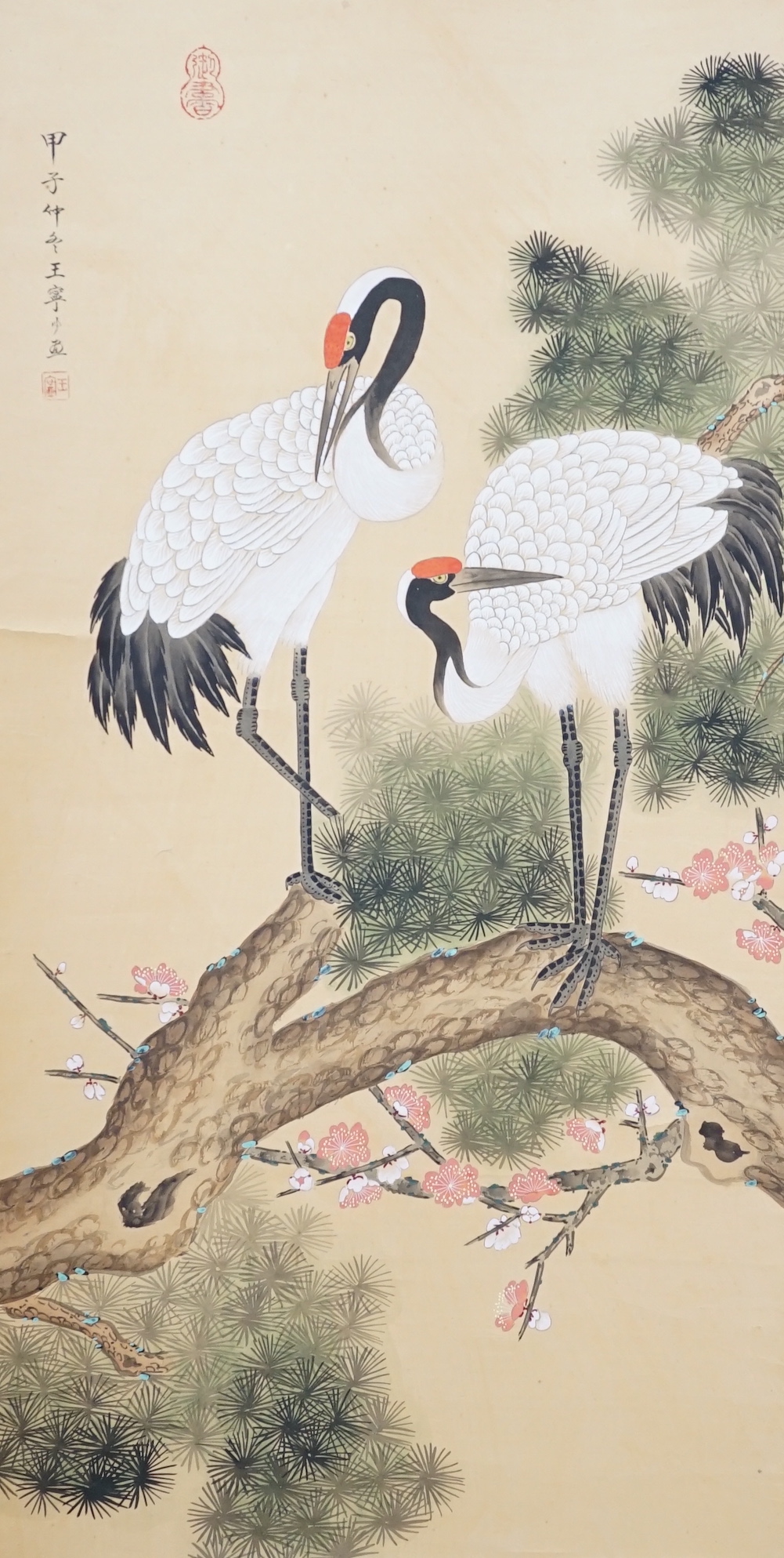 A 20th century Chinese hanging scroll watercolour on silk, two cranes on a pine tree, with brocade border, together with a blue Chinese silk table runner with brocade mon decoration